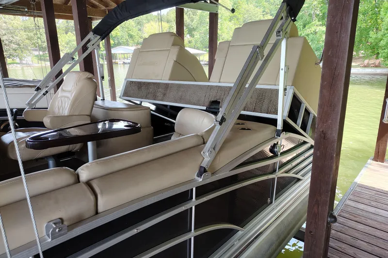 Slide: The Image of 2014 Bennington 2575 QCW I/O pontoon boat with beige seating and sleek design in dock. - 37