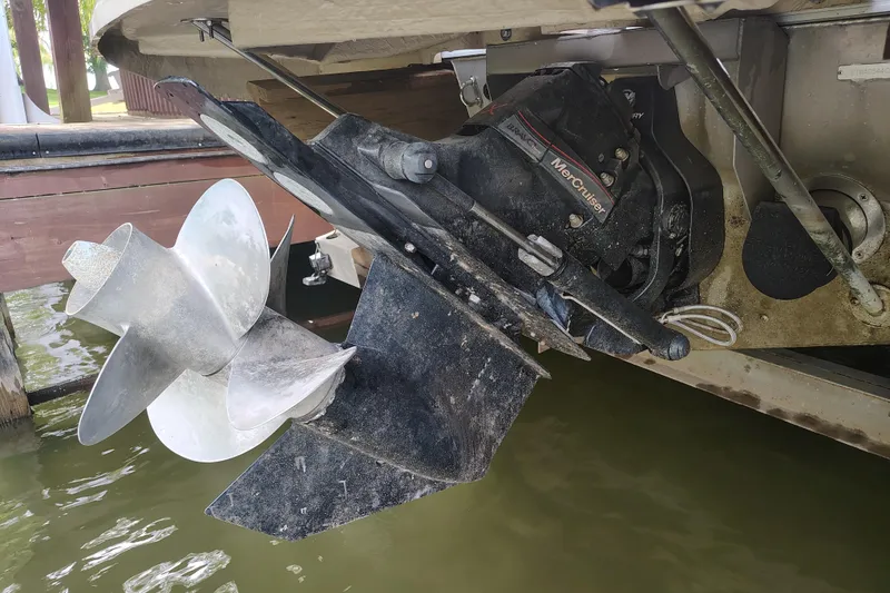 Slide: The Image of 2014 Bennington 2575 QCW I/O boat propeller and engine detail by the water. - 43
