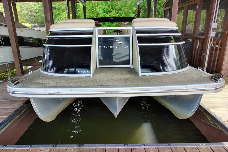 Slide: The Image of 2014 Bennington 2575 QCW I/O pontoon boat docked in a covered slip. - 5