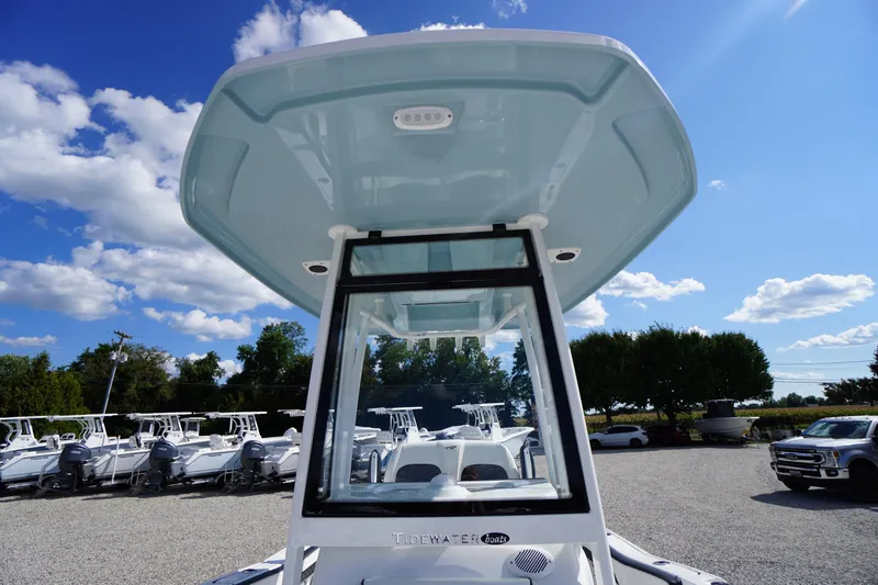 Slide: The Image of 2026 Tidewater 220 LXF boat with T-top, displayed outdoors under a clear blue sky. - 22