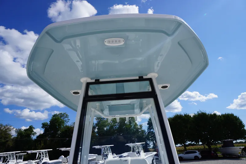 Slide: The Image of 2026 Tidewater 220 LXF boat T-top against a blue sky with clouds. - 24