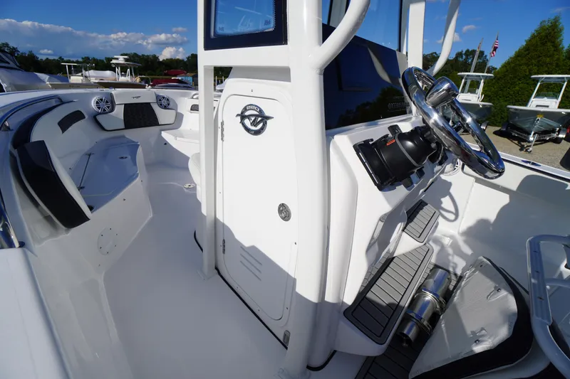 Slide: The Image of 2026 Tidewater 220 LXF boat interior with steering wheel and seating area. - 25