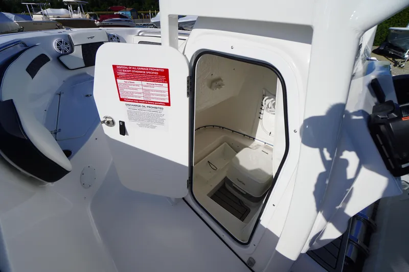 Slide: The Image of 2026 Tidewater 220 LXF boat interior with open storage compartment and seating area. - 27