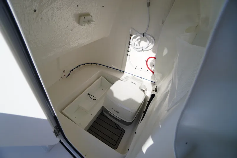 Slide: The Image of 2026 Tidewater 220 LXF boat interior with compact marine toilet and storage space. - 28