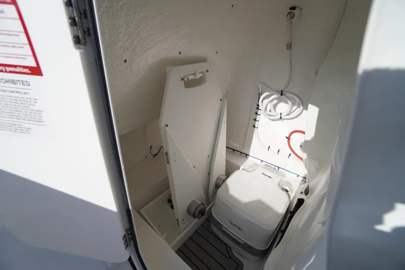 Slide: The Image of Interior of 2026 Tidewater 220 LXF boat featuring compact marine toilet setup. - 30