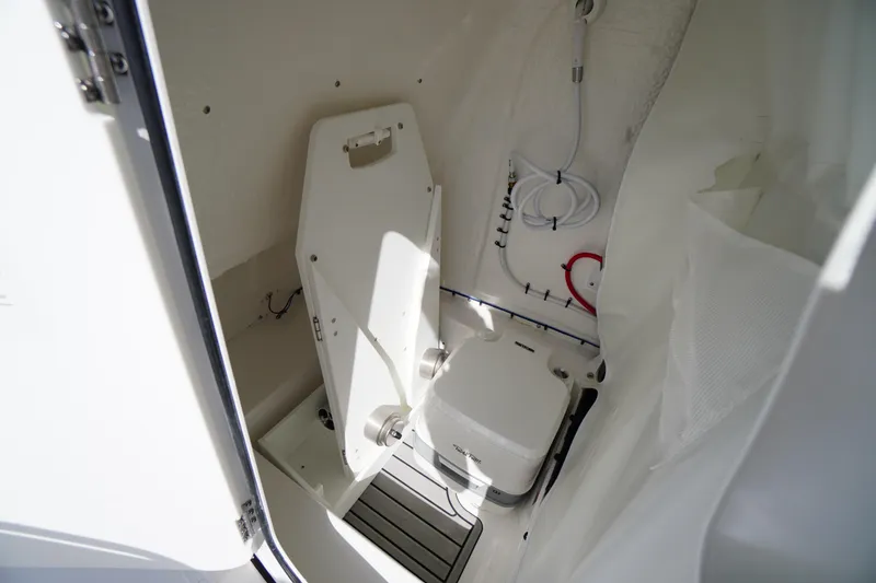 Slide: The Image of Interior of 2026 Tidewater 220 LXF boat featuring compact marine toilet setup. - 32