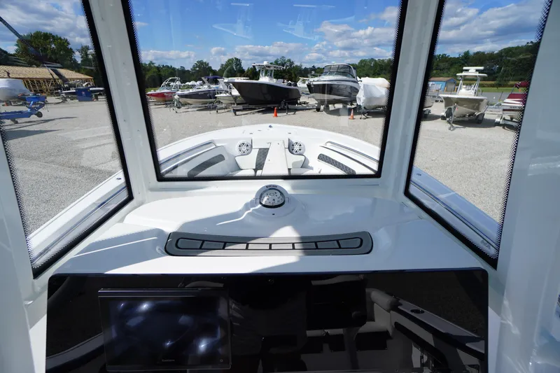 Slide: The Image of 2026 Tidewater 220 LXF boat dashboard view with marina background. - 39
