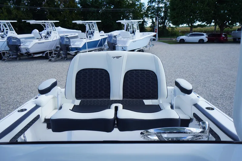 Slide: The Image of 2026 Tidewater 220 LXF boat interior with dual seats, parked among other boats. - 48