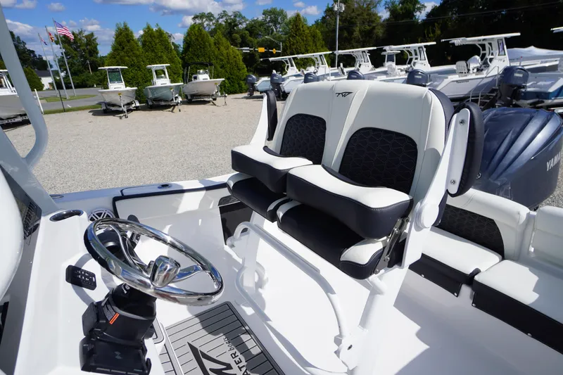 Slide: The Image of 2026 Tidewater 220 LXF boat interior with dual seats and steering wheel. - 51