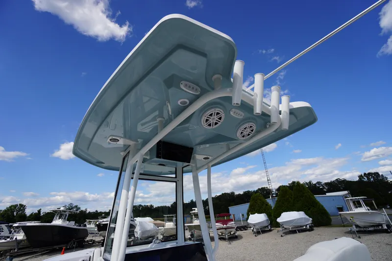Slide: The Image of 2026 Tidewater 220 LXF boat with T-top and rod holders under a clear blue sky. - 65