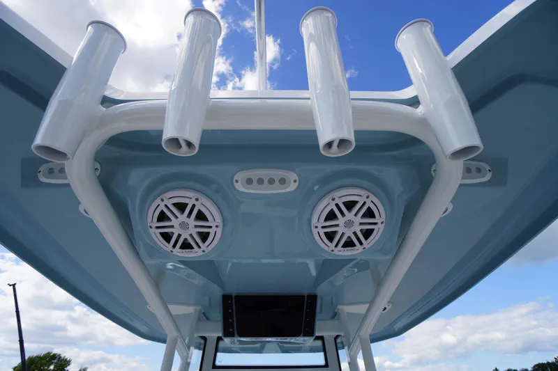 Slide: The Image of Tidewater 220 LXF 2026 boat with rod holders and speakers under blue sky. - 66