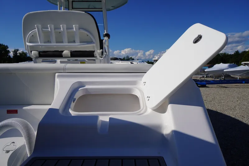 Slide: The Image of 2026 Tidewater 220 LXF boat with open storage compartment, sunny day, clear blue sky. - 72