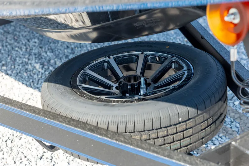 Slide: The Image of 2026 Skeeter FXR21 Apex trailer tire on gravel surface. - 10