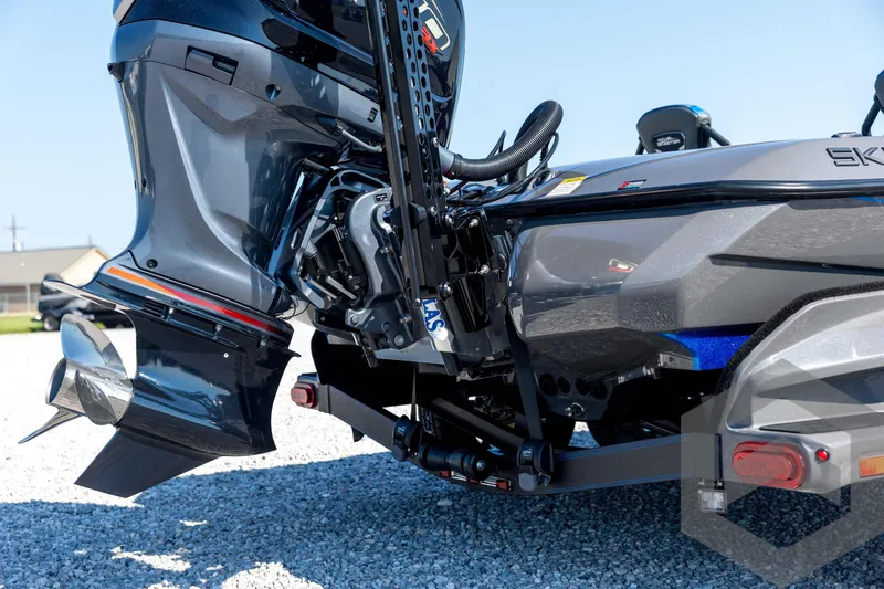Slide: The Image of 2026 Skeeter FXR21 Apex boat engine close-up on gravel surface. - 17