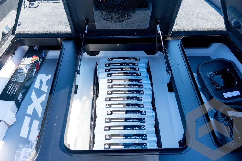 Slide: The Image of 2026 Skeeter FXR21 Apex boat storage compartment with organized tackle boxes. - 48