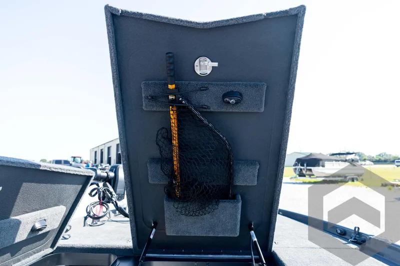 Slide: The Image of 2026 Skeeter FXR21 Apex boat storage compartment with fishing net and equipment. - 53