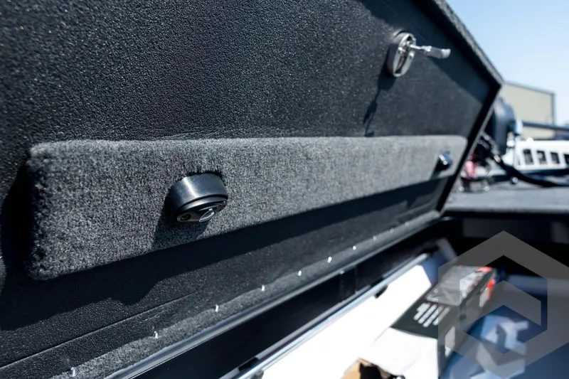 Slide: The Image of 2026 Skeeter FXR21 Apex storage compartment with lock and carpeted interior. - 54