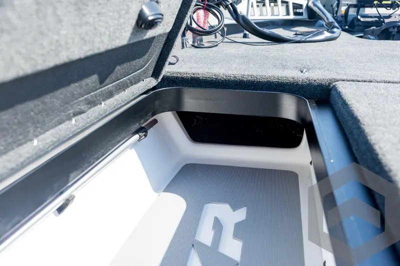 Slide: The Image of 2026 Skeeter FXR21 Apex boat storage compartment with carpeted interior and wiring details. - 55