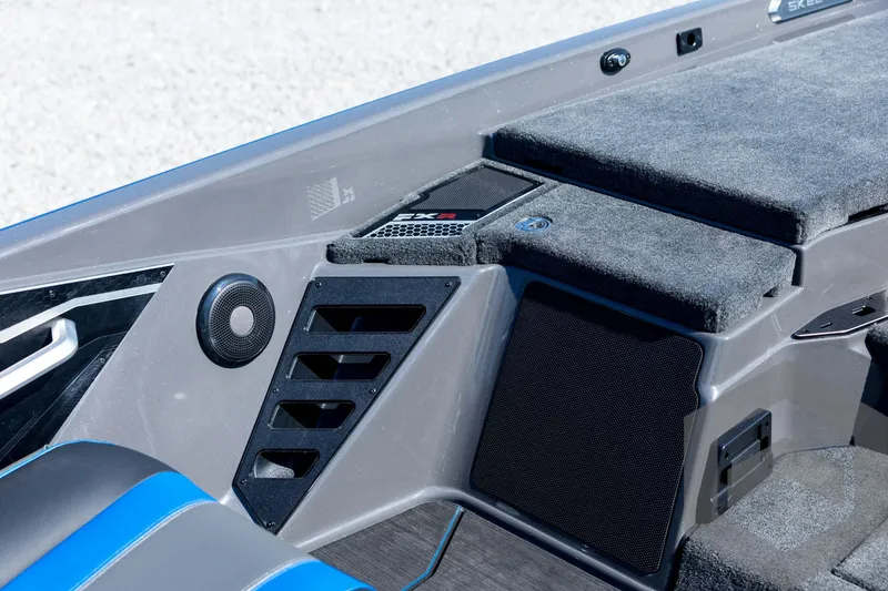 Slide: The Image of 2026 Skeeter FXR21 Apex boat interior with speaker and carpeted storage. - 64