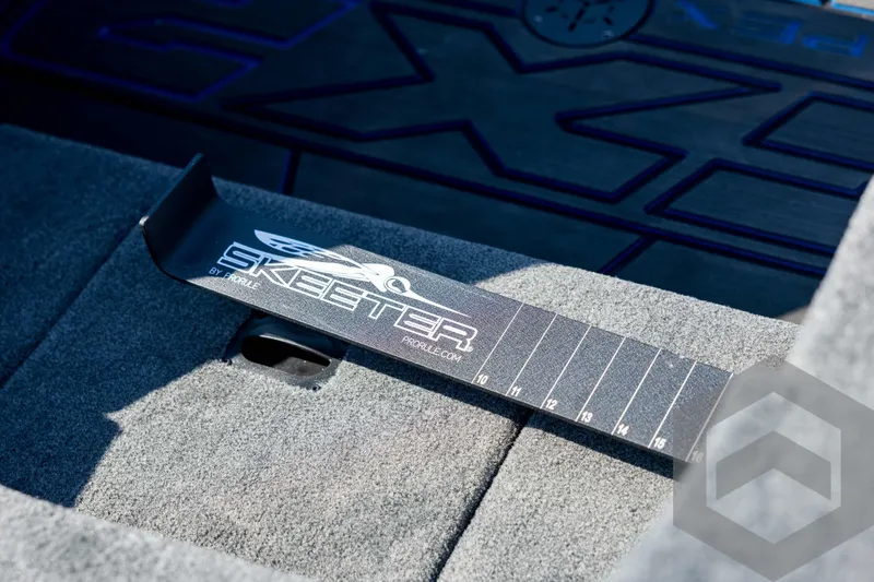 Slide: The Image of Skeeter FXR21 Apex 2026 boat interior with branded measuring tool on carpeted surface. - 65