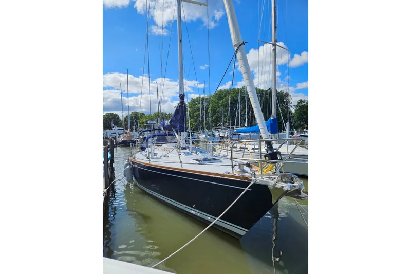 Slide: The Image of 1988 Tartan 40 sailboat docked in a marina under a clear blue sky. - 1