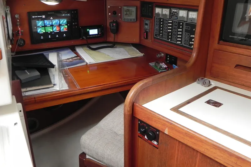 Slide: The Image of Navigation station inside a 1988 Tartan 40 sailboat, featuring charts and electronic equipment. - 23