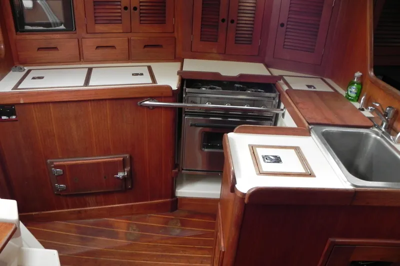 Slide: The Image of 1988 Tartan 40 yacht kitchen with wooden cabinetry, stove, and sink. - 24