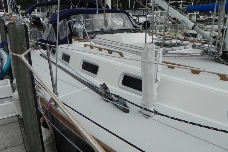 Slide: The Image of 1988 Tartan 40 sailboat docked, featuring sleek white deck and blue canopy. - 4