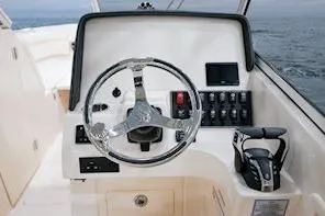 Slide: The Image of 2026 Grady-White Freedom 275 boat dashboard with steering wheel and controls. - 14