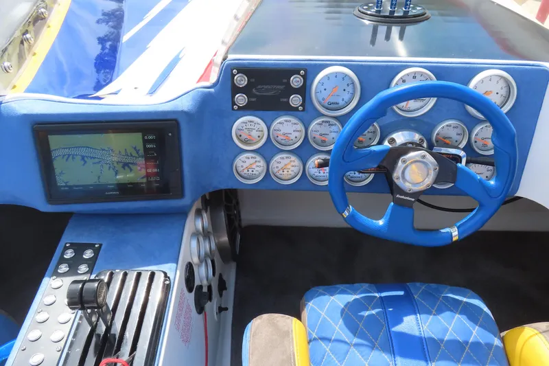 Slide: The Image of Cockpit of 2003 Spectre 36 Cat with blue steering wheel and multiple gauges. - 14