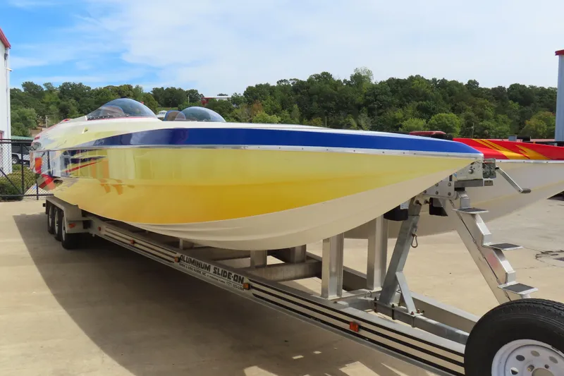 Slide: The Image of 2003 Spectre 36 Cat powerboat on trailer, featuring vibrant yellow and blue design. - 4