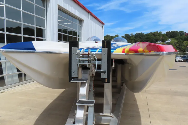 Slide: The Image of 2003 Spectre 36 Cat powerboat with vibrant colors on a trailer outside a garage. - 5