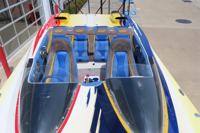 Slide: The Image of 2003 Spectre 36 Cat boat with vibrant blue and yellow seating, docked outdoors. - 8