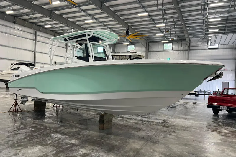 Slide: The Image of 2026 Wellcraft 302 Fisherman boat in a spacious indoor storage facility. - 1