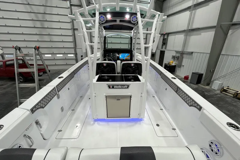 Slide: The Image of 2026 Wellcraft 302 Fisherman boat interior in a spacious garage setting. - 11