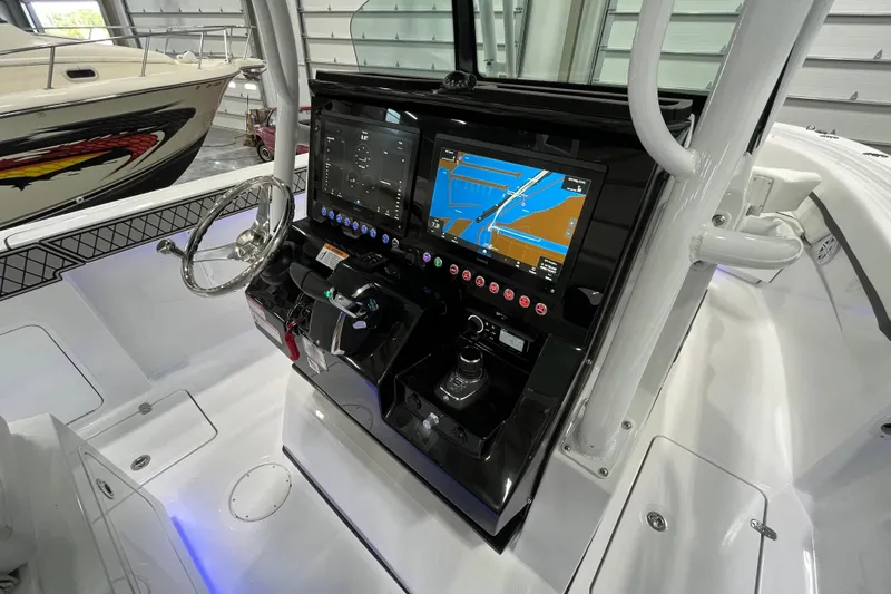 Slide: The Image of 2026 Wellcraft 302 Fisherman boat dashboard with navigation screens and steering wheel. - 18
