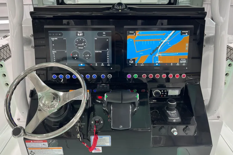 Slide: The Image of 2026 Wellcraft 302 Fisherman dashboard with dual Garmin displays and modern controls. - 19