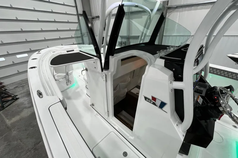 Slide: The Image of 2026 Wellcraft 302 Fisherman boat interior with open cabin door in a garage setting. - 22