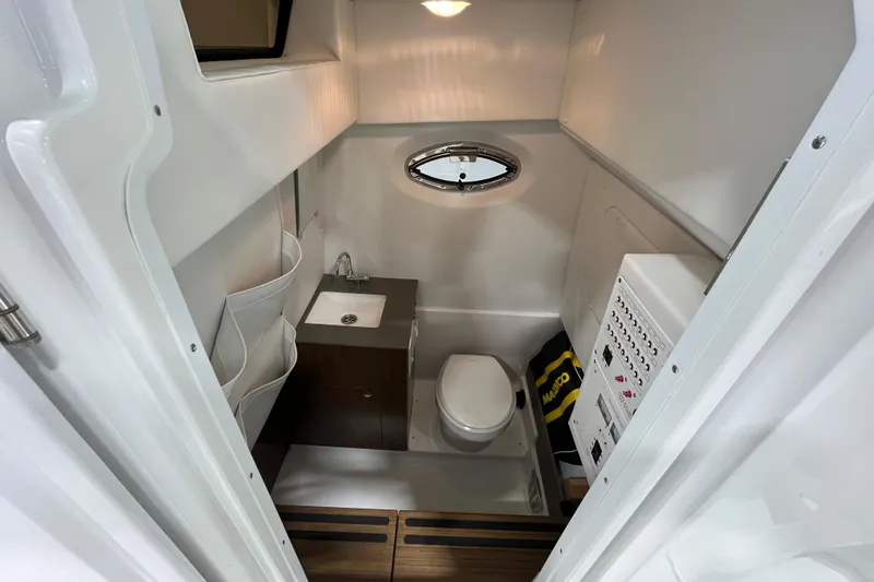 Slide: The Image of 2026 Wellcraft 302 Fisherman boat interior bathroom with sink, toilet, and storage. - 23