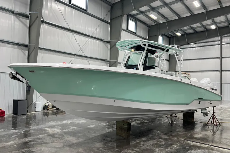 Slide: The Image of 2026 Wellcraft 302 Fisherman boat in a spacious indoor storage facility. - 3