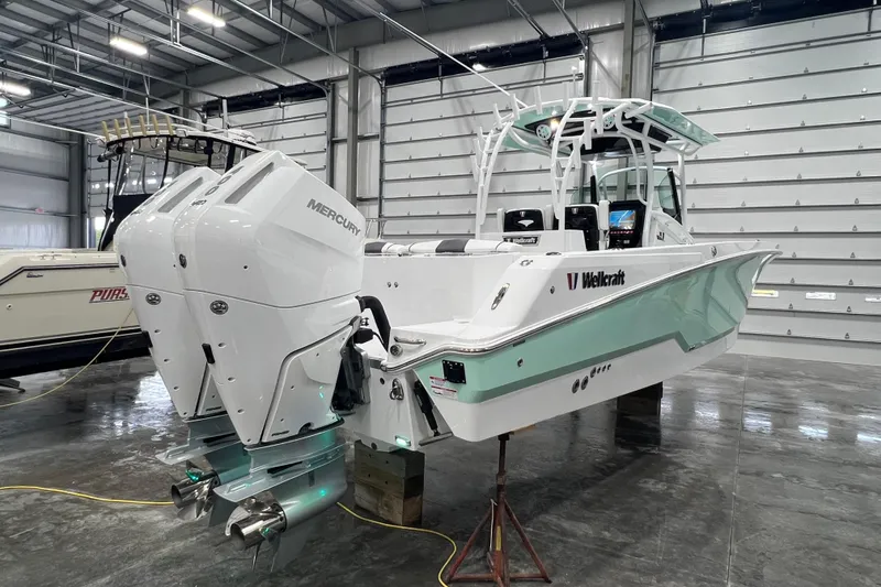 Slide: The Image of 2026 Wellcraft 302 Fisherman boat with dual Mercury engines in a showroom. - 7