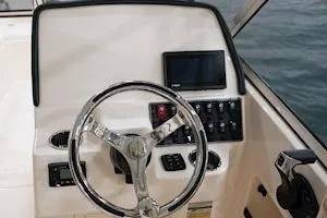 Slide: The Image of 2026 Grady-White Freedom 235 boat dashboard with steering wheel and control panel. - 12