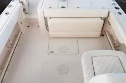 Slide: The Image of 2026 Grady-White Freedom 235 boat interior with white seating and storage compartments. - 13