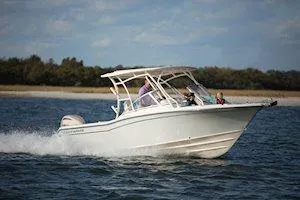 Slide: The Image of 2026 Grady-White Freedom 235 boat cruising on open water under a clear sky. - 6