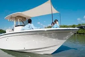 Slide: The Image of 2026 Grady-White Fisherman 257 boat on water, featuring a sunshade and two passengers. - 11