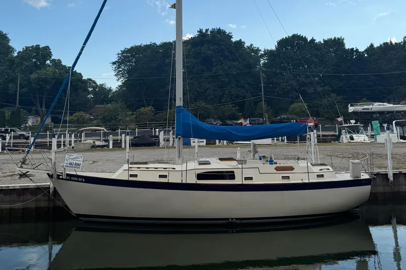 Slide: The Image of 1977 Irwin 37 Mark III sailboat docked at a marina, surrounded by trees. - 2