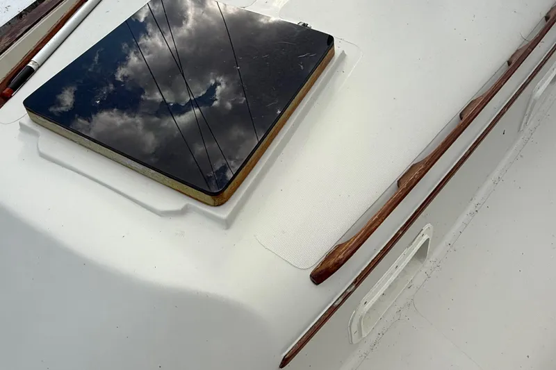 Slide: The Image of 1977 Irwin 37 Mark III yacht deck with reflective hatch and wooden trim. - 23