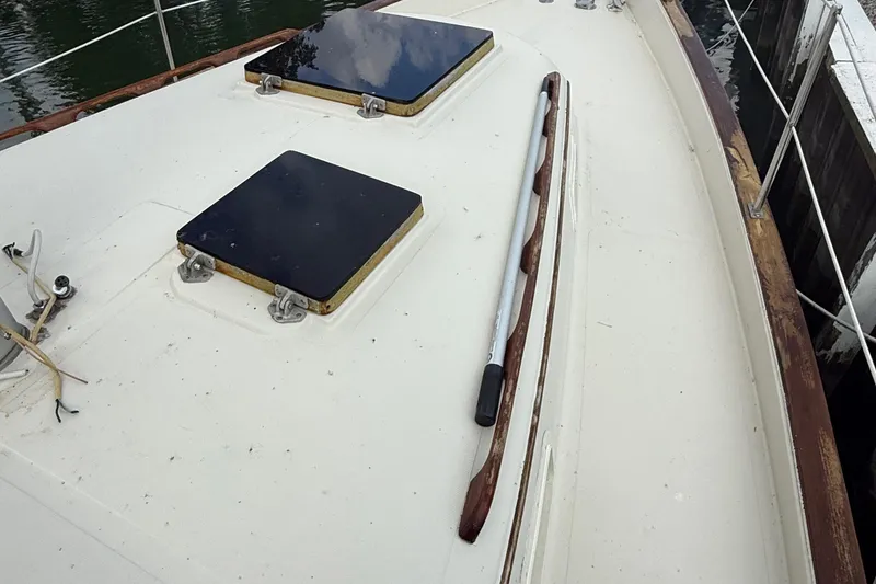 Slide: The Image of 1977 Irwin 37 Mark III sailboat deck with hatches and wooden handrails. - 27