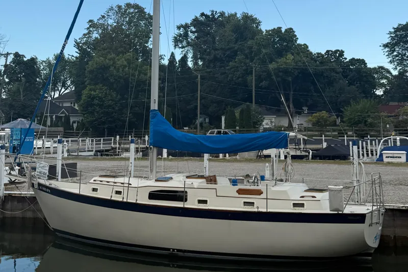 Slide: The Image of 1977 Irwin 37 Mark III sailboat docked at a marina with blue sail cover. - 3