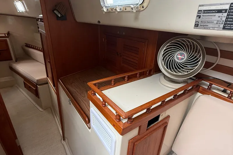 Slide: The Image of Interior of a 1977 Irwin 37 Mark III sailboat with wooden cabinetry and a fan. - 32